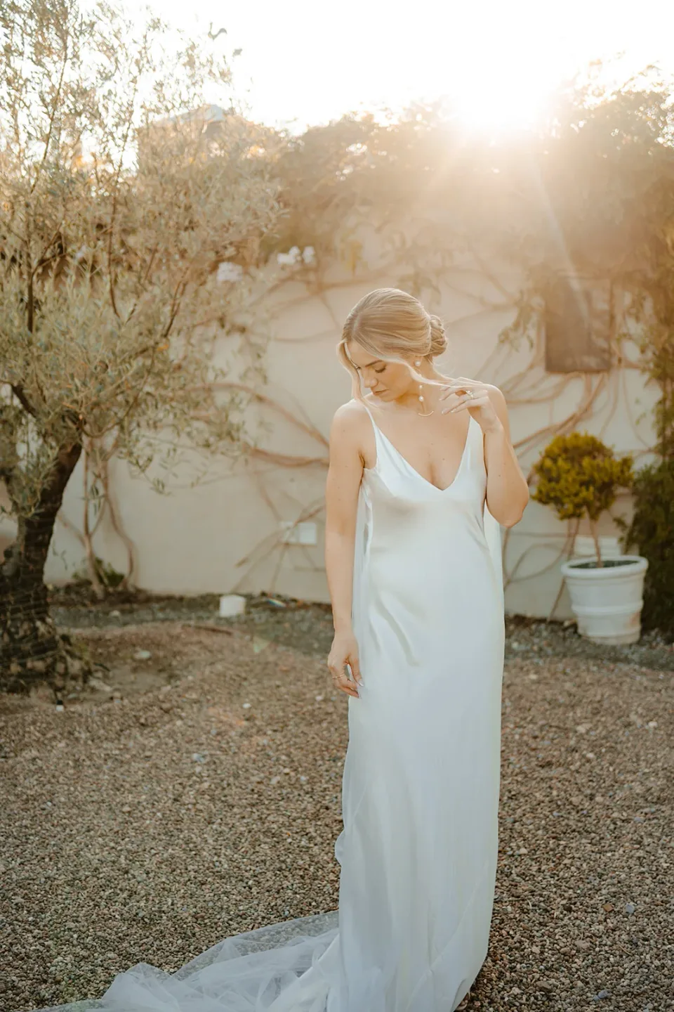 Novia iluminada por el sol con maquillaje suave y un elegante recogido