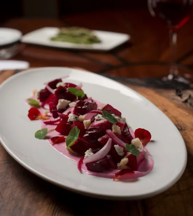 Ensalada de betabel servida con queso, hierbas y cebolla encurtida de The Restaurant