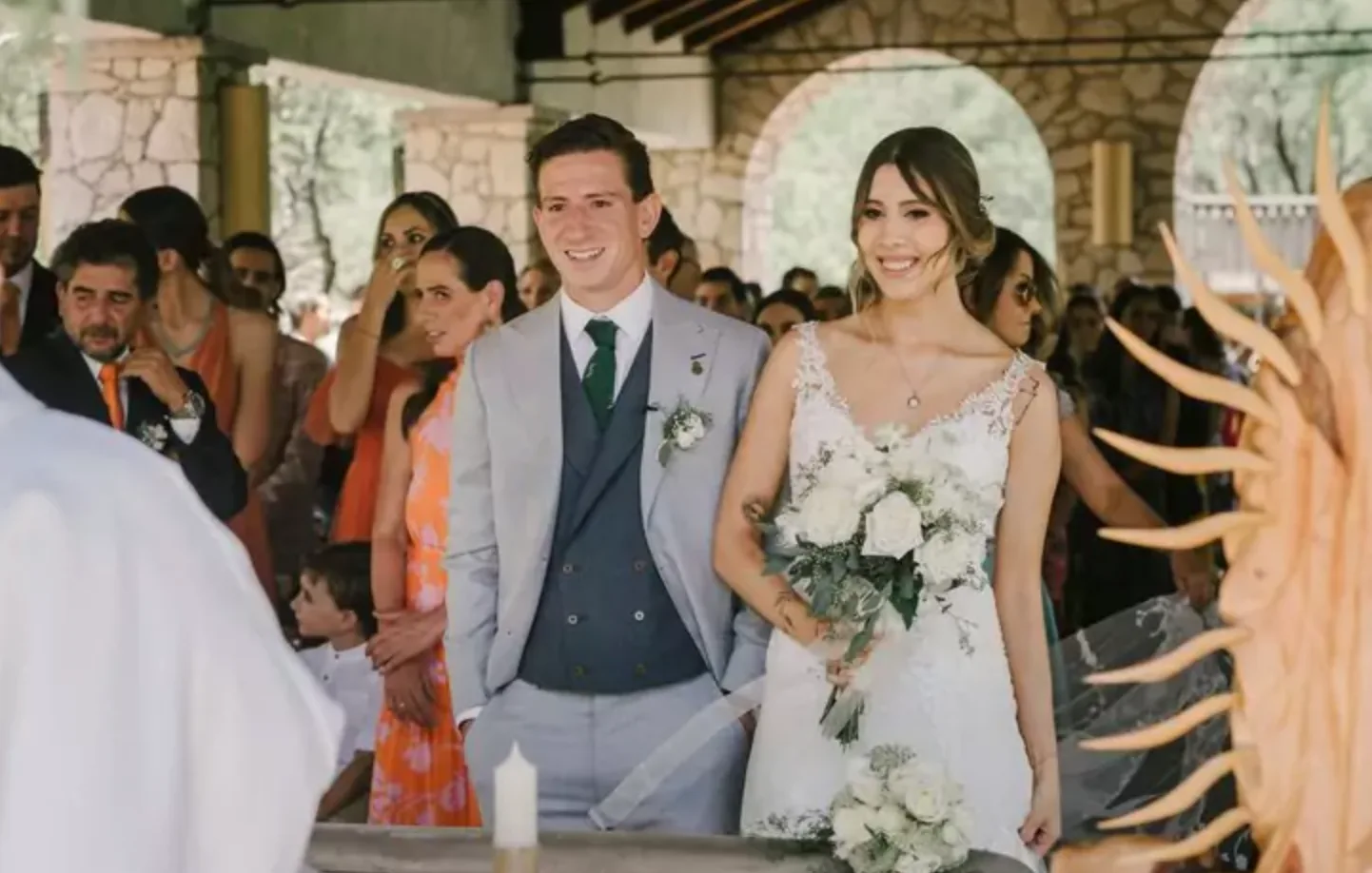 Recién casados sonriendo durante una ceremonia de boda al aire libre