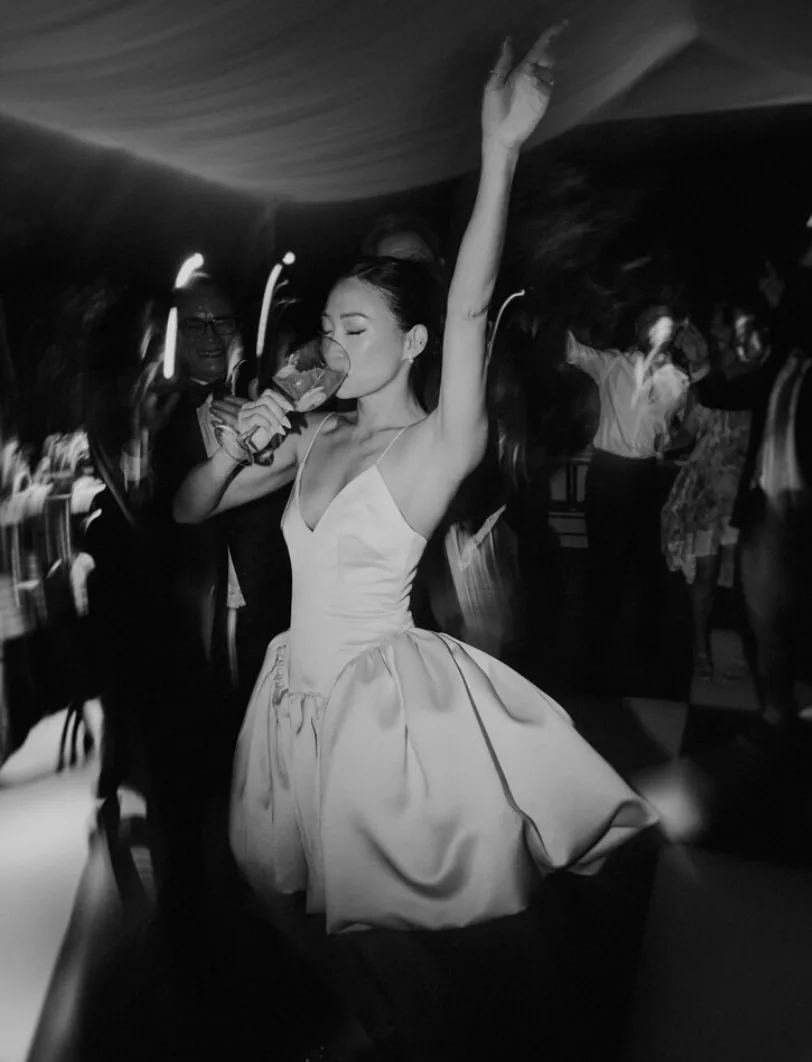 Fotografía espontánea en blanco y negro de una novia celebrando en la pista de baile