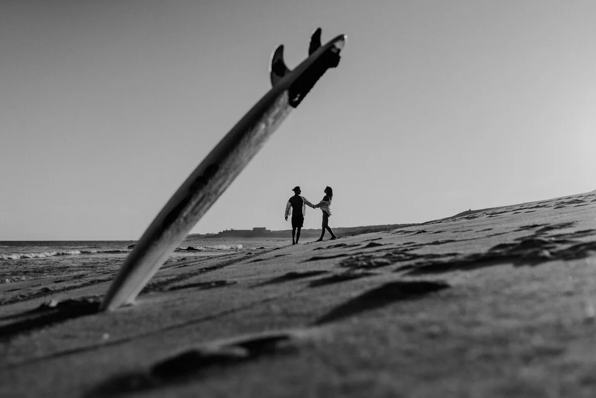 Retrato divertido de pareja destino con una tabla de surf