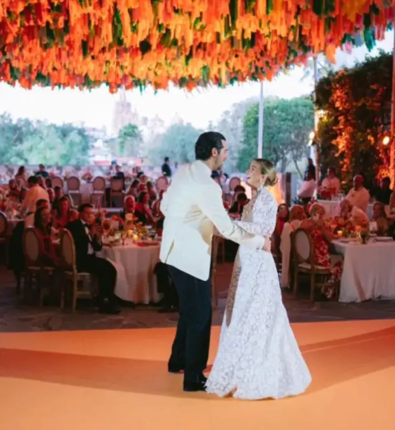Recién casados durante su primer baile bajo una vibrante decoración suspendida en una boda de Penzi