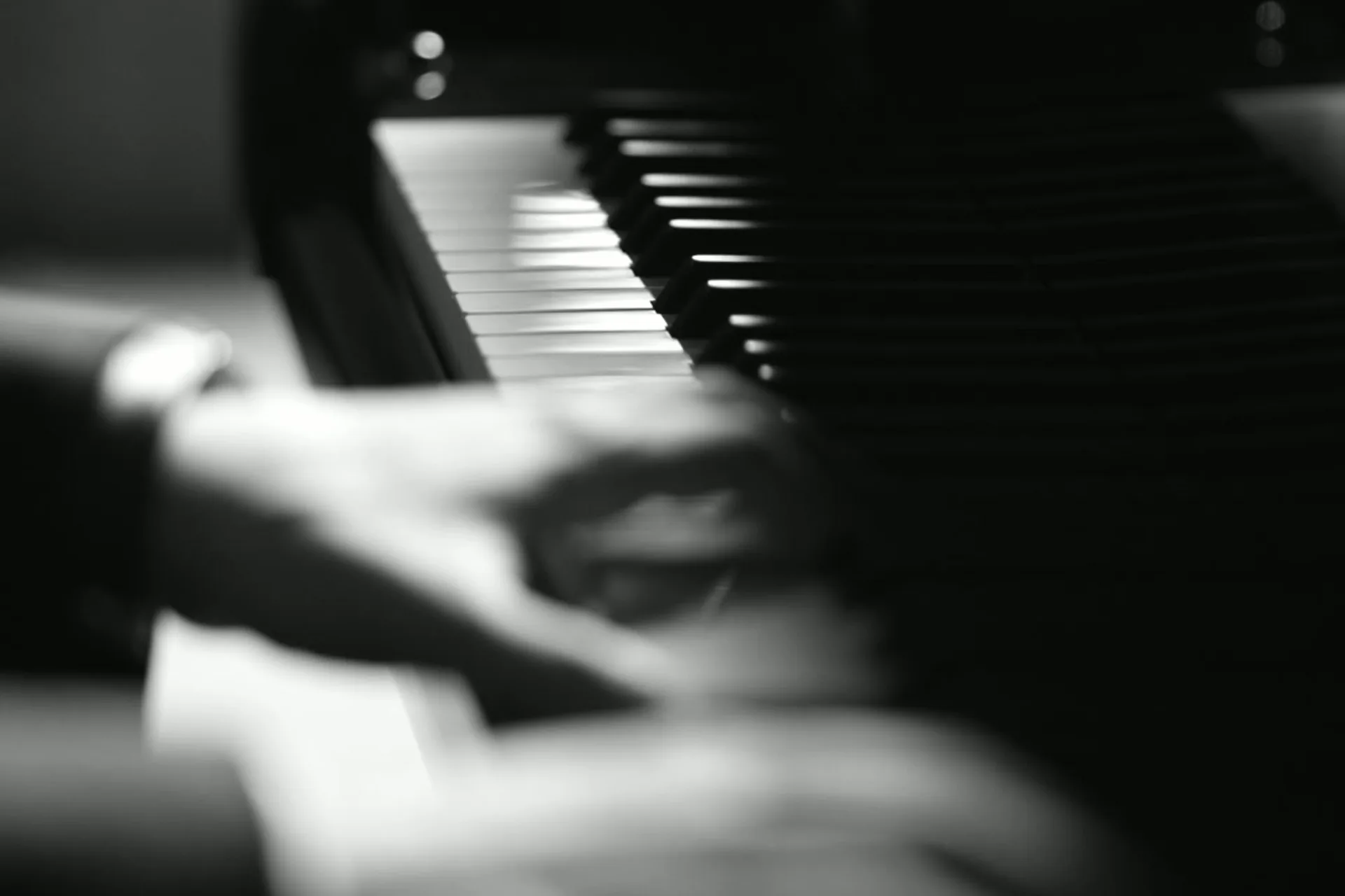 Primer plano cinematográfico de manos tocando el piano