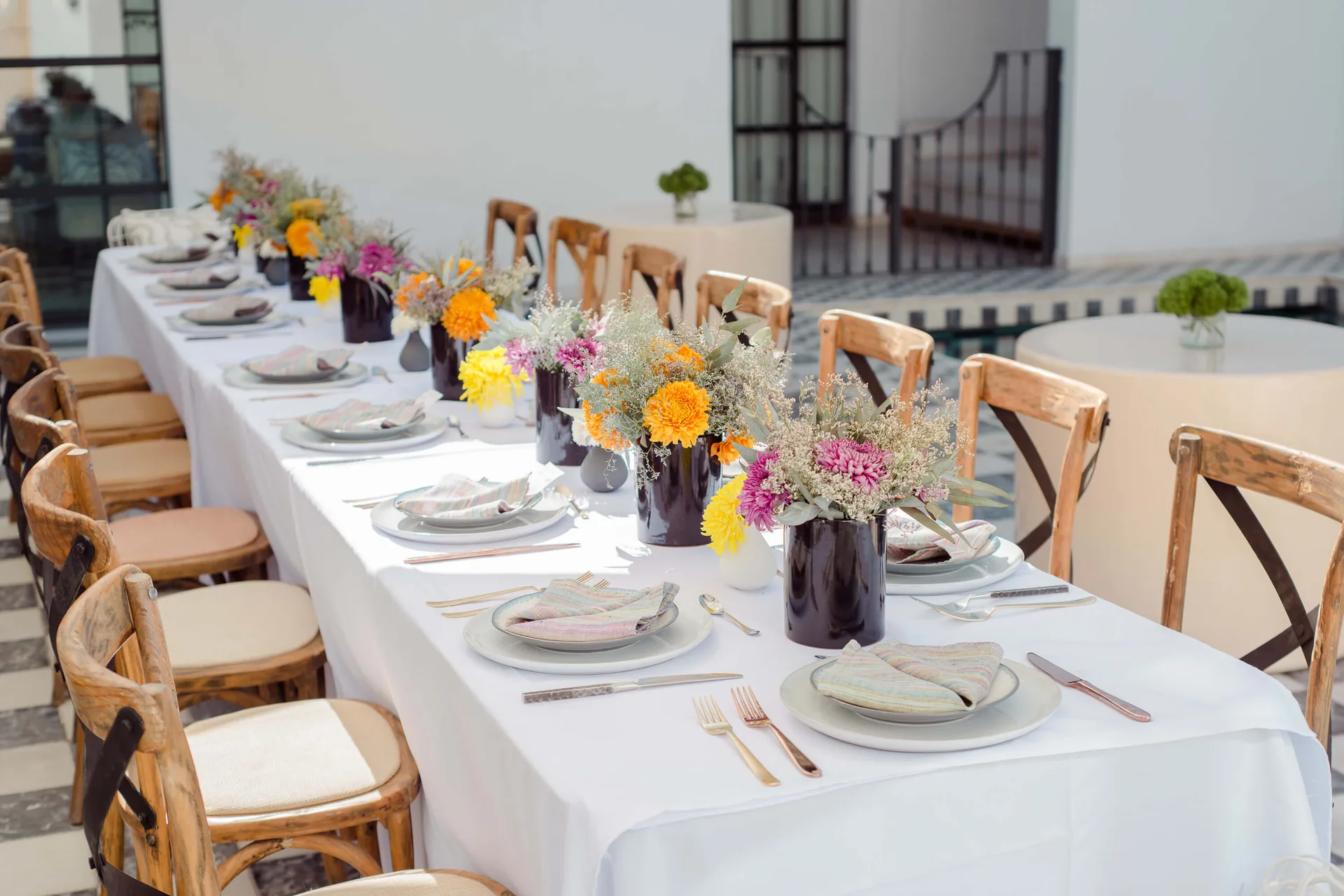 Mesa larga de recepción con flores de colores en Casa Arca