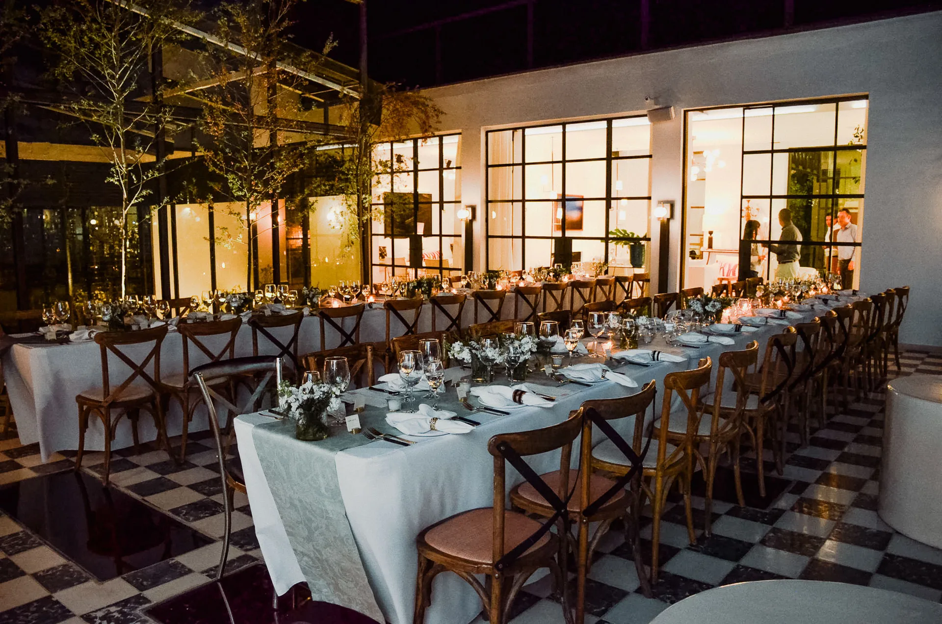 Mesas para cena nocturna en el patio de Casa Arca