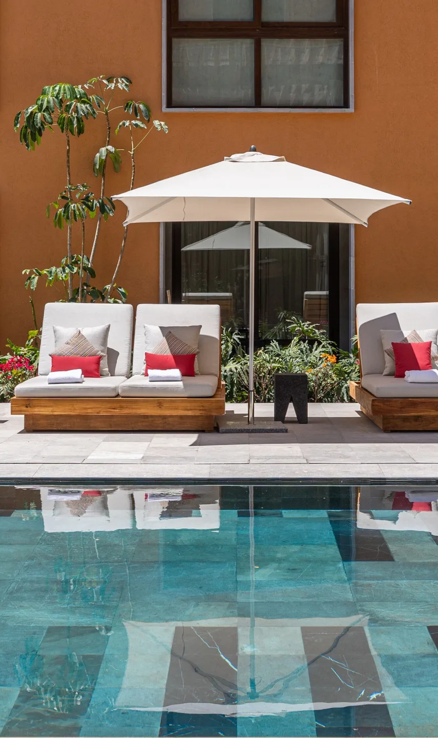 Área de descanso junto a la piscina en un patio interior de Cleviá San Miguel de Allende
