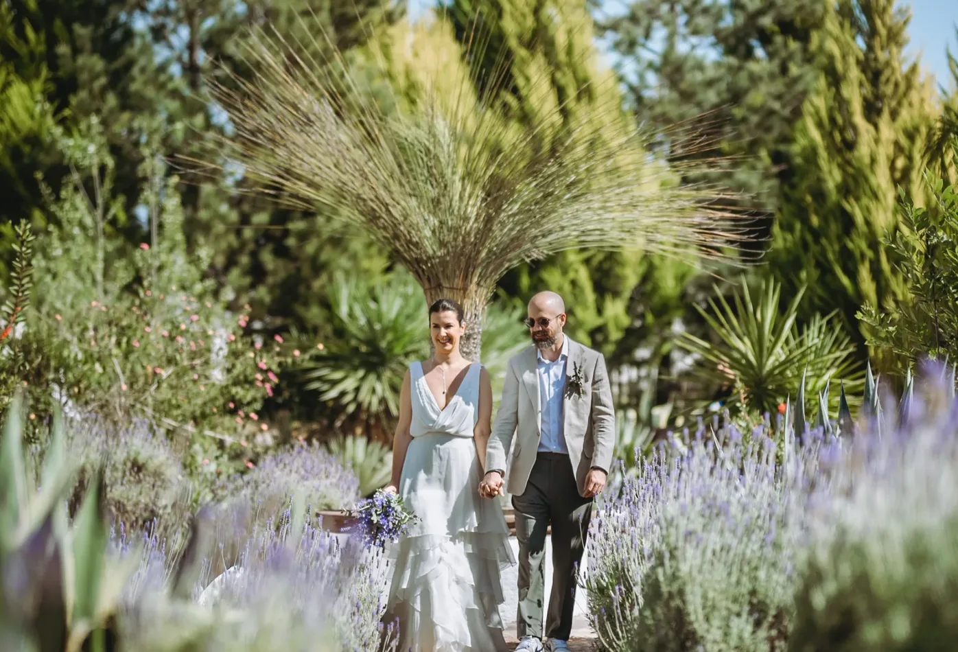 Pareja de recién casados caminando por los jardines de Hacienda Agualuna