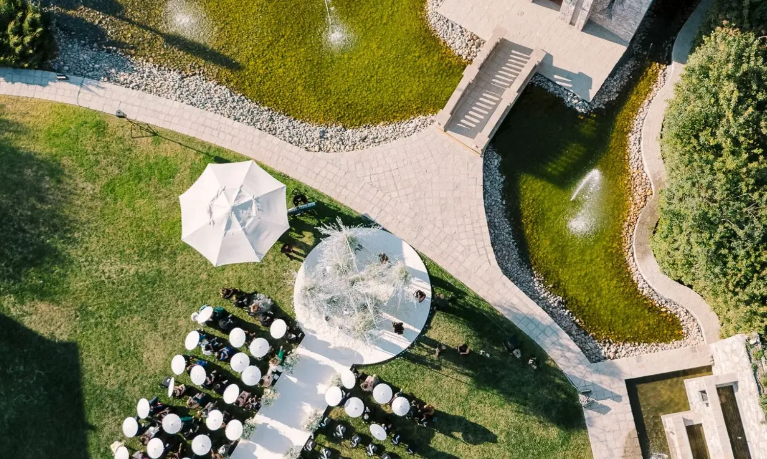 Vista aérea de una ceremonia de boda al aire libre junto a los jardines acuáticos