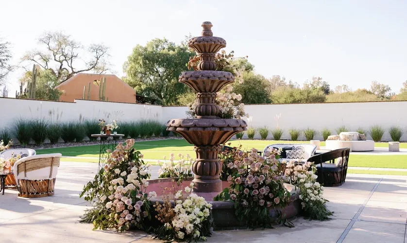 Fuente de la hacienda rodeada de flores y mobiliario de sala al aire libre