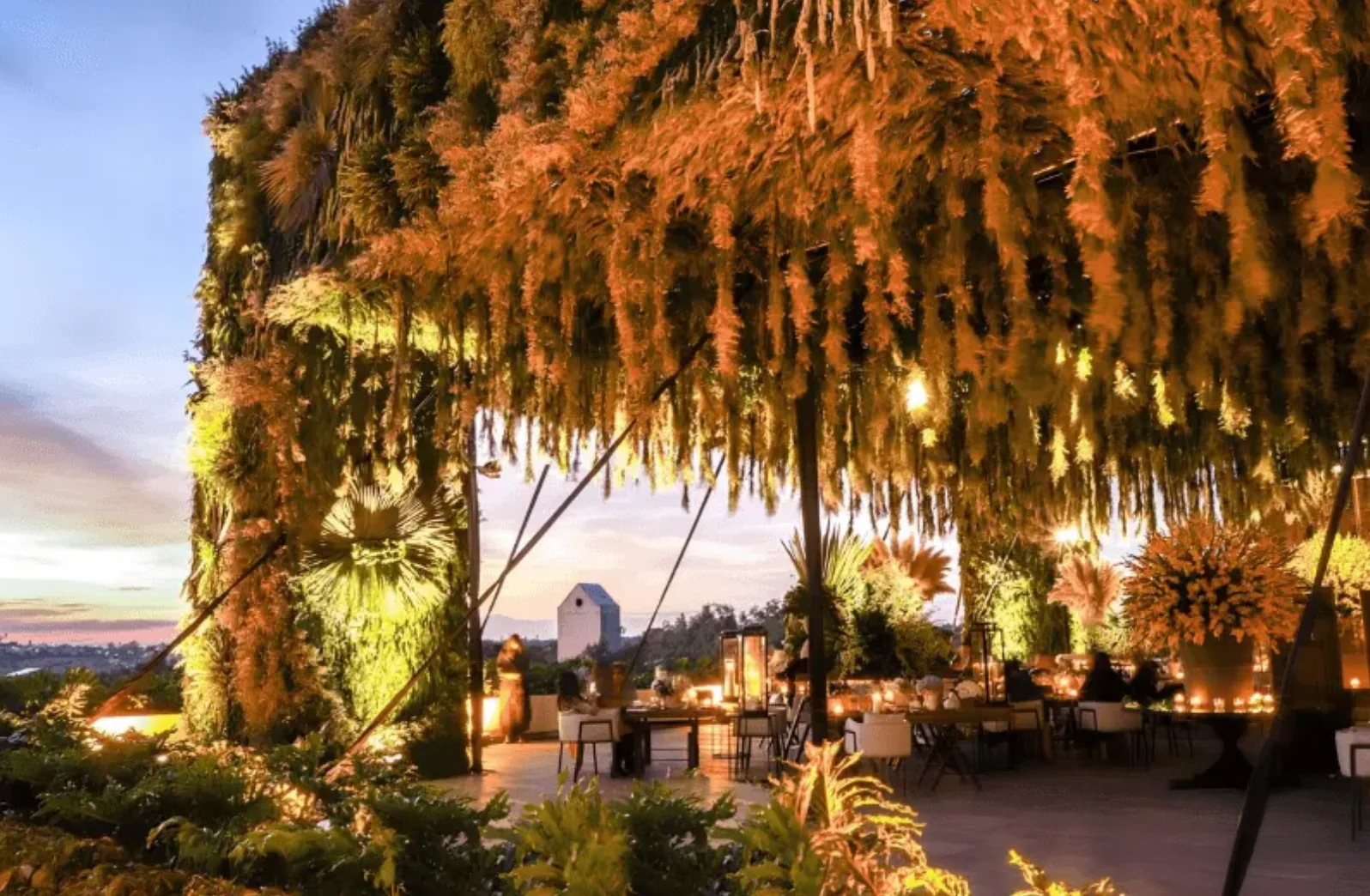 Recepción nocturna en el jardín bajo un dosel floral en Live Aqua